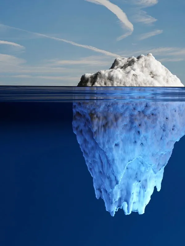 Iceberg floating in the ocean with most of its mass underwater